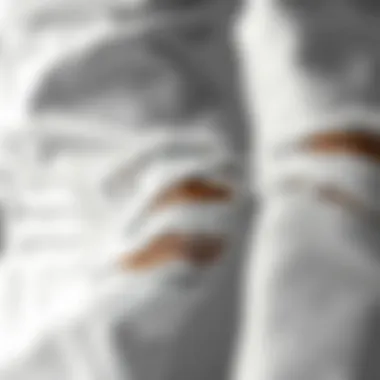 Close-up of the texture and details of ripped white jeans